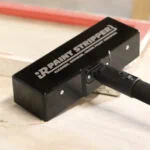 Black iR Paint Stripper head on a wood surface, white logo reading Cleaner, Quicker, Safer