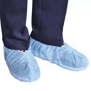 Blue disposable shoe booties worn over dress shoes with navy pants