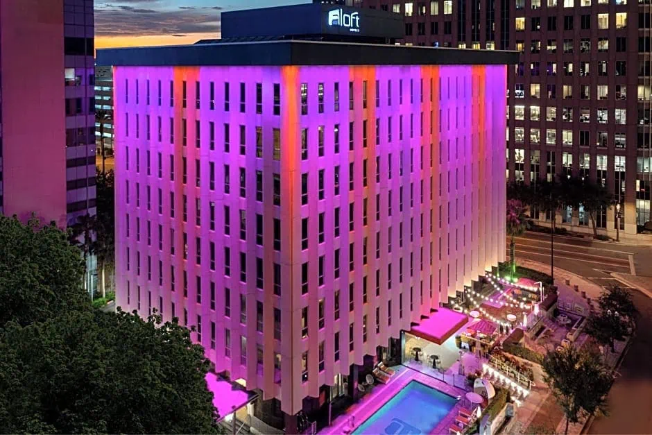 Colorful building with pink and purple lighting at night.
